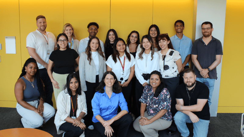 NAARE students and USC faculty smiling in front of yellow background