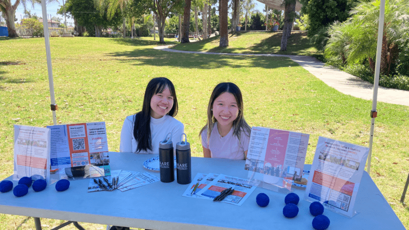 Staff and students smile at a table